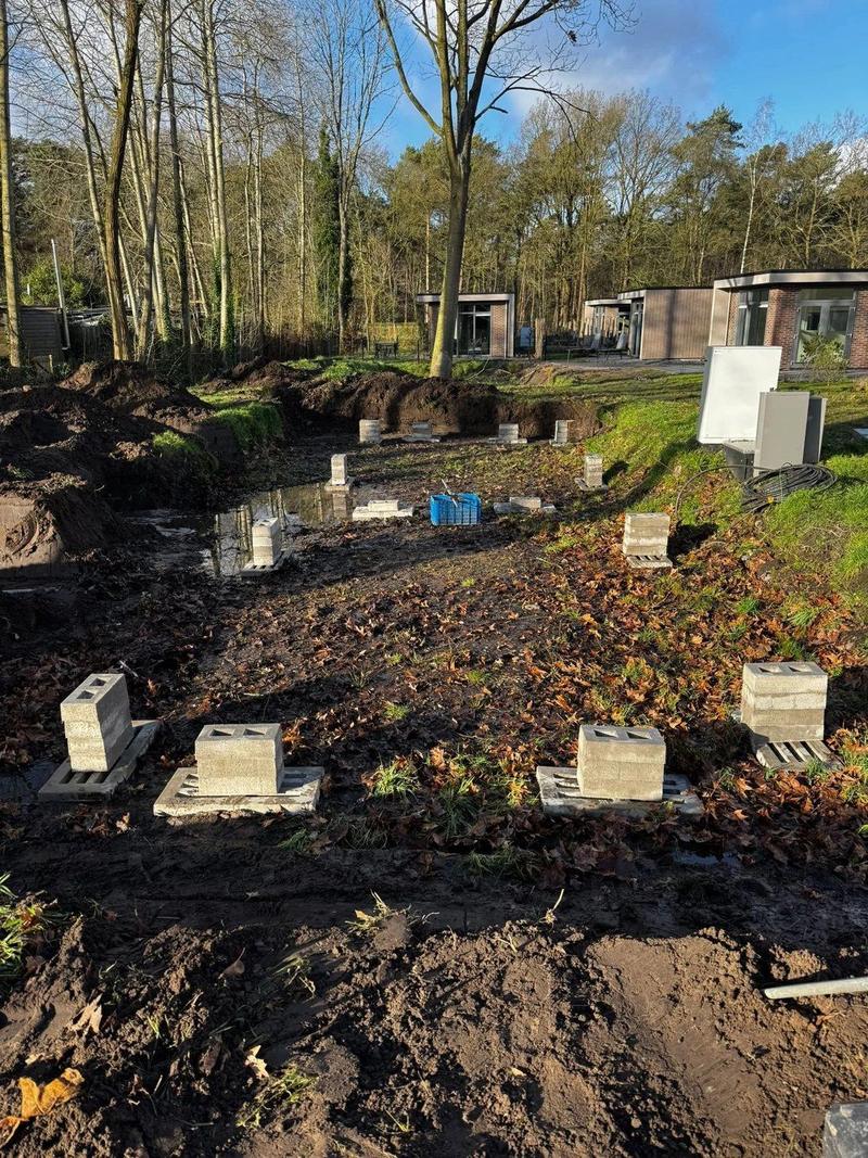 Grondplaten klaargelegd op een bouwplek in het bos